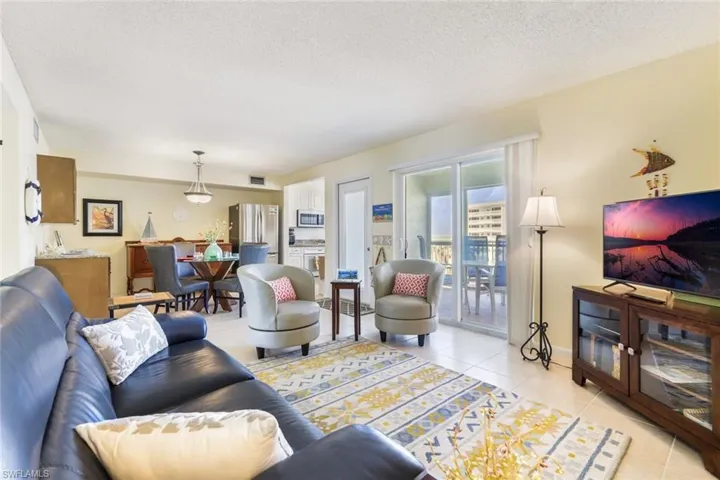 Living room with a textured ceiling and light tile patterned floors
