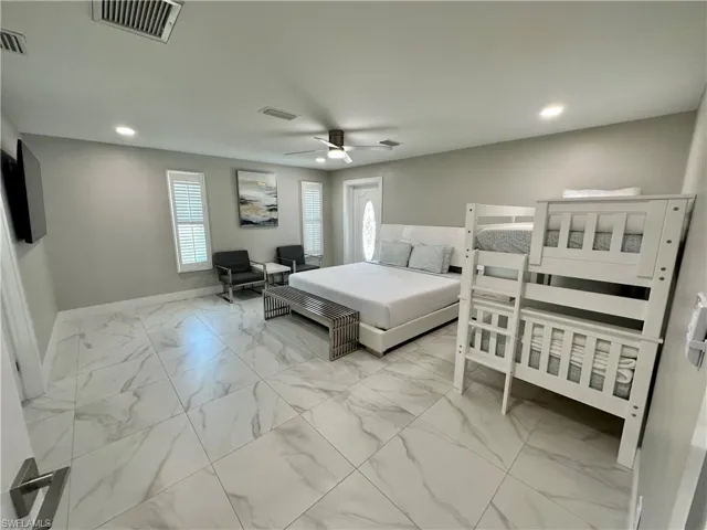 Bedroom with light marble finish floors, recessed lighting, and a ceiling fan