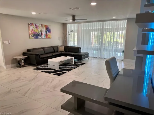 Living area featuring light marble finish floors, a ceiling fan, and recessed lighting