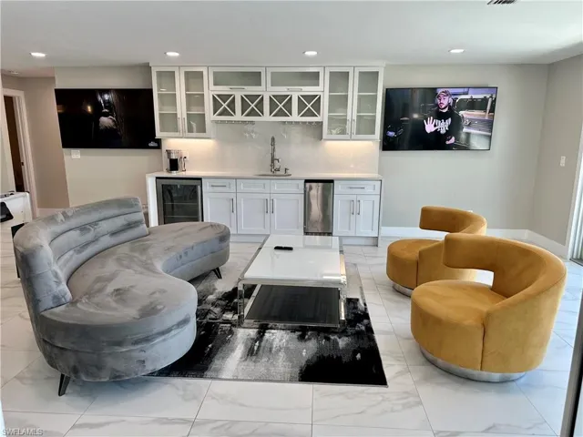 Living room with bar with sink, wine cooler, and recessed lighting