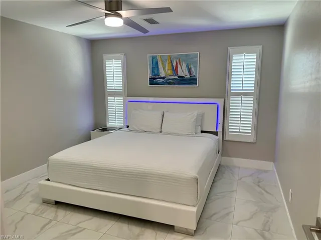 Bedroom with light marble finish floors and ceiling fan