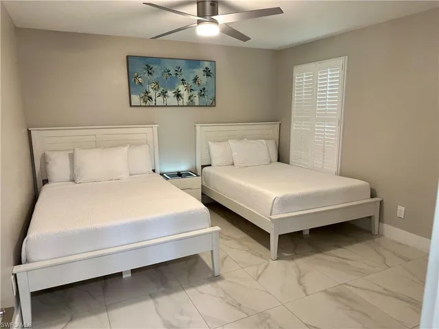 Bedroom featuring light marble finish flooring and ceiling fan