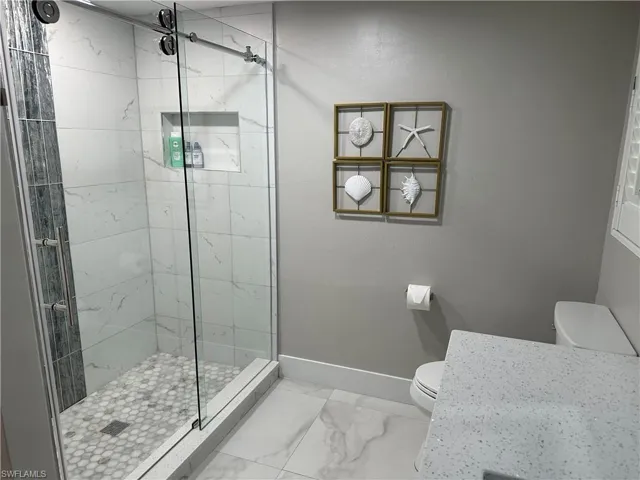 Full bathroom with a stall shower and light marble finish flooring
