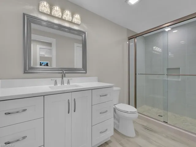 Bathroom with vanity, a shower stall, and light wood finished floors