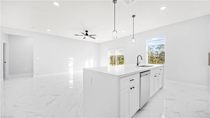 Kitchen with light marble finish floors, pendant lighting, white cabinetry, recessed lighting, and light stone countertops