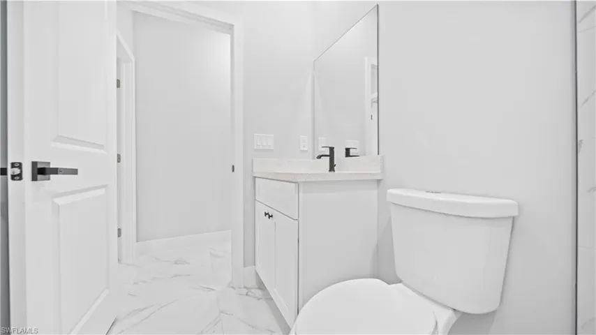 Bathroom with vanity and light marble finish flooring