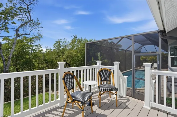 Wooden terrace with glass enclosure, an outdoor pool, and a sunroom - Virtually Edited Image