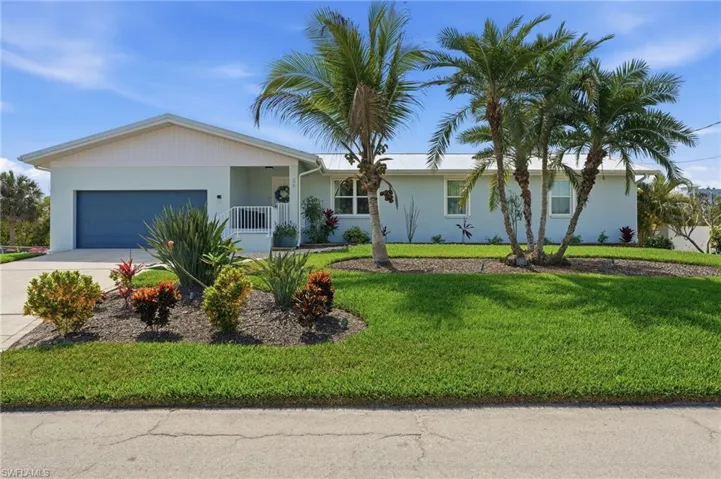 Ranch-style home with a garage, driveway, stucco siding, and a front yard - Virtually Edited Image