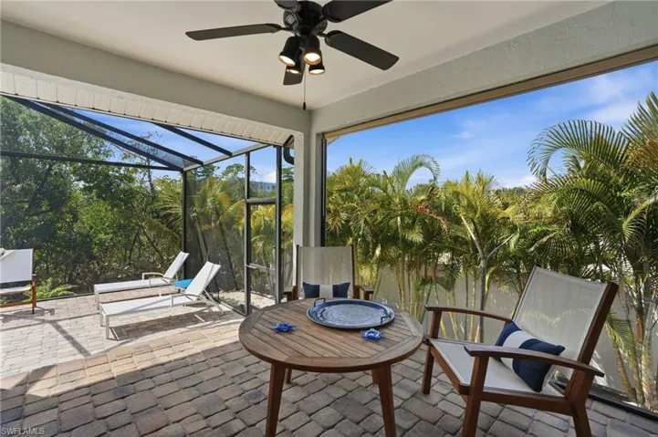Sunroom featuring ceiling fan, a patio area, and a fire pit - Virtually Edited Image
