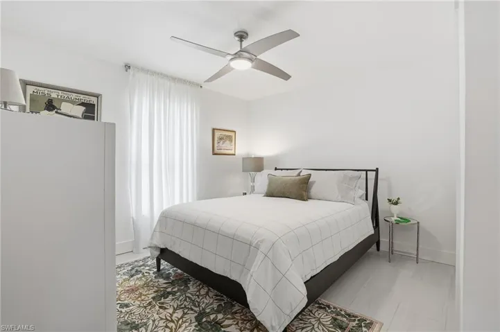 Bedroom featuring a ceiling fan and baseboards - Virtually Edited Image