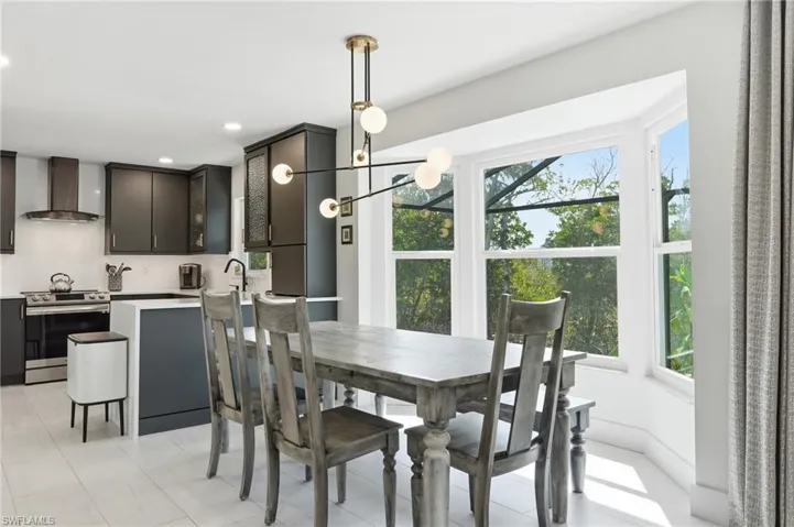 Dining area featuring suspended lighting and light tile patterned floors - Virtually Edited Image