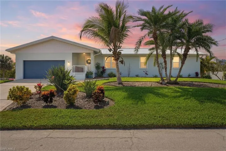 Ranch-style house with a garage, driveway, stucco siding, a porch, and a lawn - Virtually Edited Image