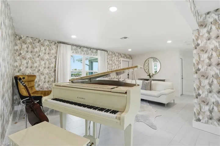 Sitting room with wallpapered walls and recessed lighting - Virtually Edited Image