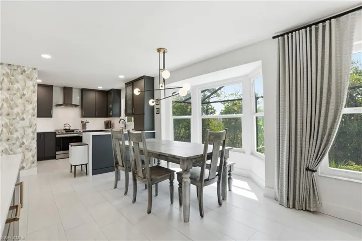 Dining space with a chandelier and light tile patterned flooring - Virtually Edited Image