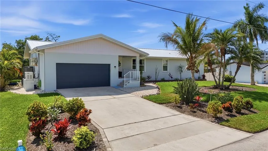 Ranch-style house featuring an attached garage, concrete driveway, a front yard, and a metal roof - Virtually Edited Image