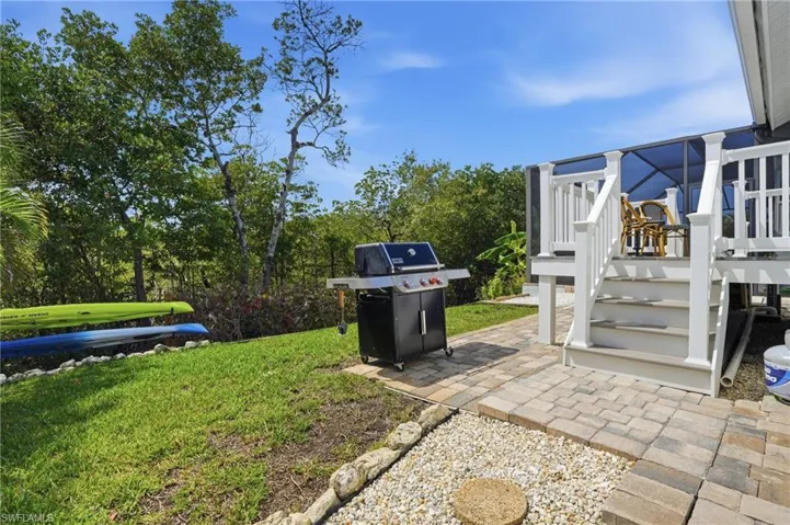 View of green lawn featuring a patio and a deck - Virtually Edited Image