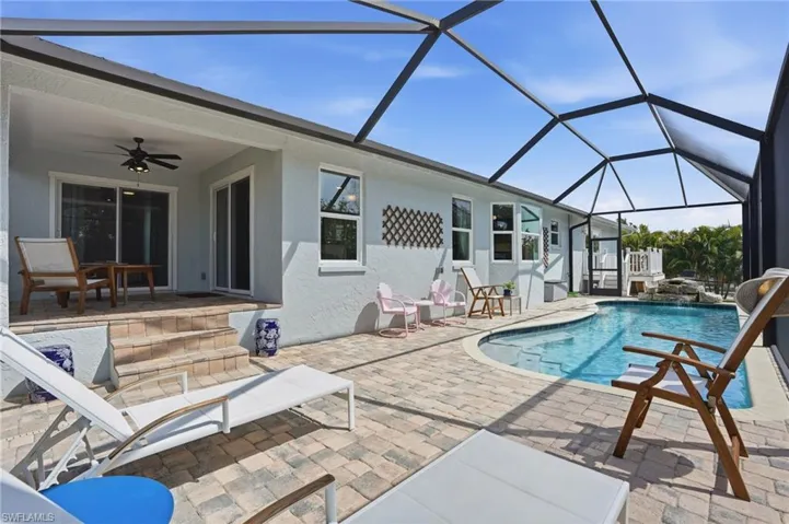 Swimming pool with a patio area, a sunroom, and a lanai - Virtually Edited Image