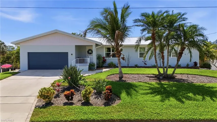 Ranch-style home with a garage, concrete driveway, a front lawn, and stucco siding - Virtually Edited Image