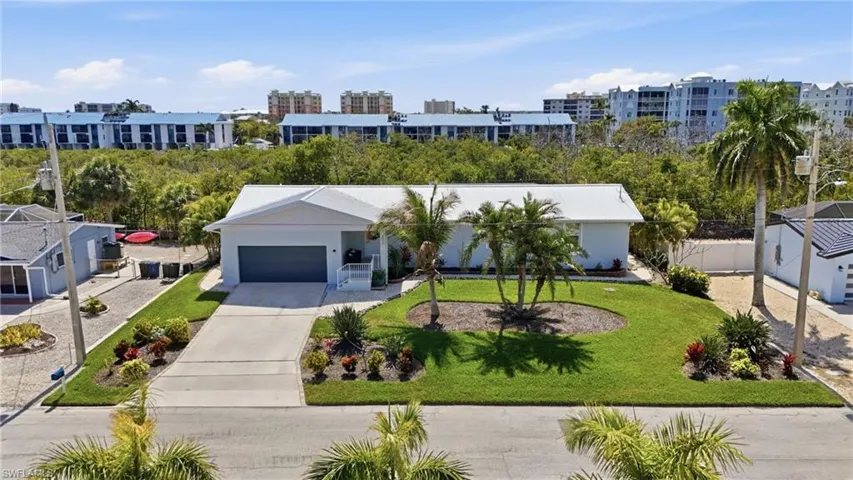 View of front of home featuring concrete driveway, an attached garage, a front yard, and stucco siding - Virtually Edited Image