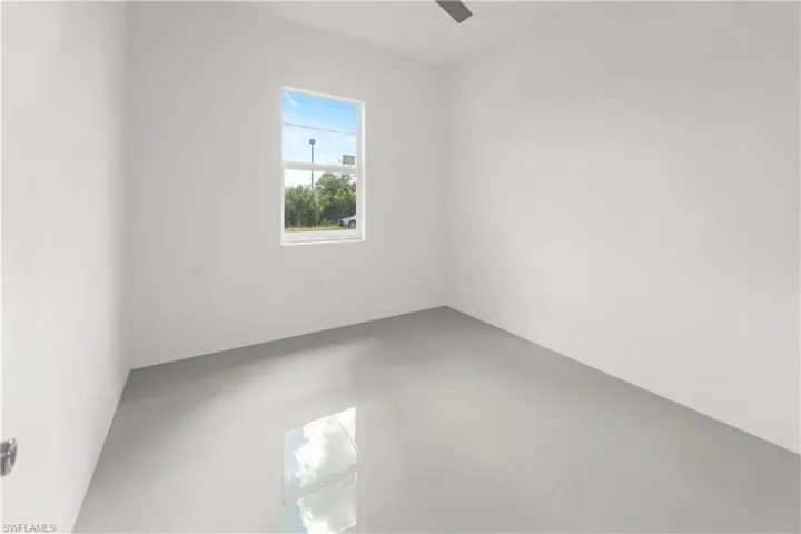 Empty room featuring finished concrete floors and baseboards