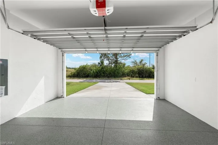 Garage featuring a garage door opener and electric panel