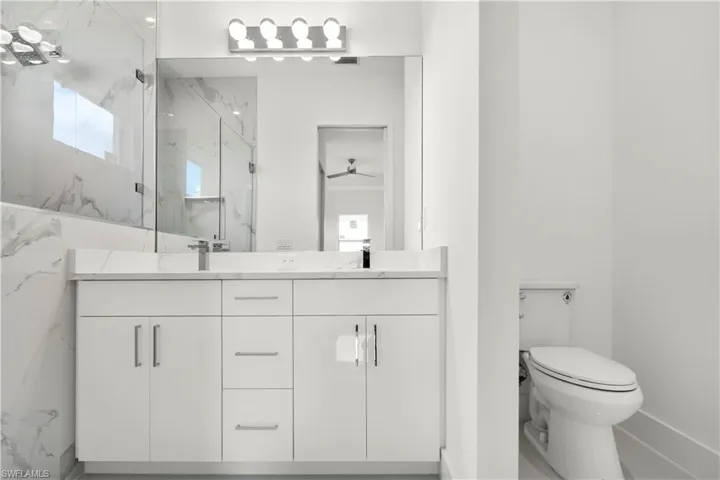 Full bathroom with a marble finish shower and double vanity
