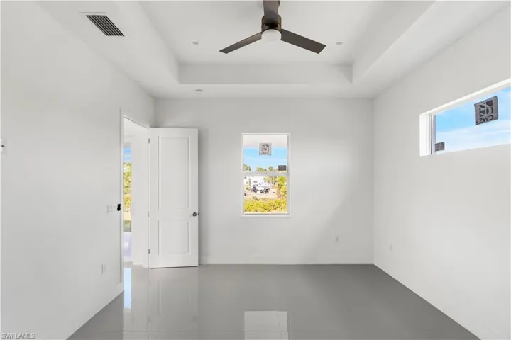 Spare room with plenty of natural light, a raised ceiling, and ceiling fan