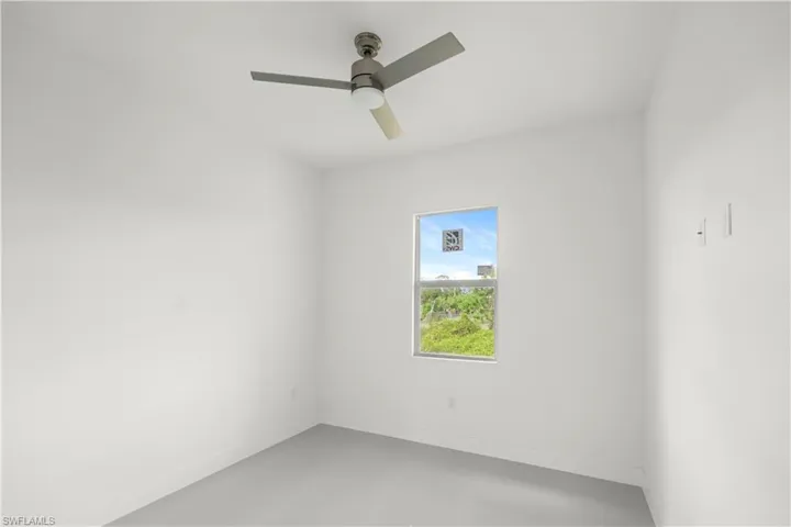 Unfurnished room with a ceiling fan and concrete floors