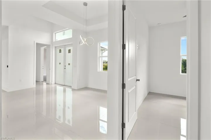 Entryway featuring a raised ceiling and a chandelier