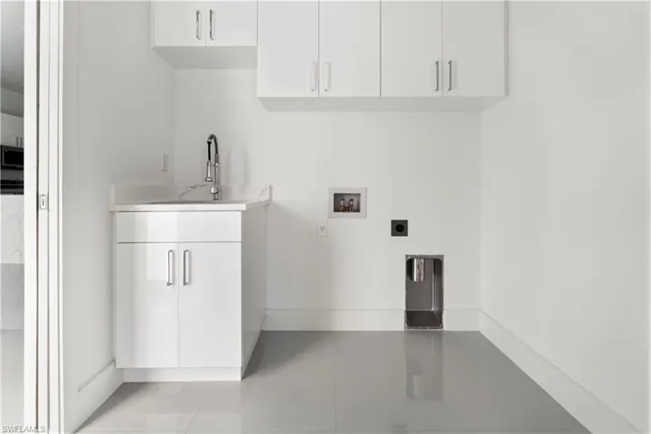 Laundry area featuring hookup for a washing machine, electric dryer hookup, and cabinet space