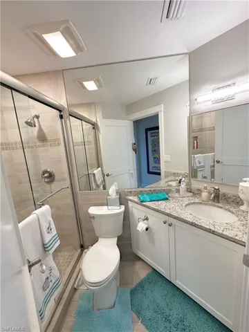 Full bathroom featuring double vanity and a shower stall