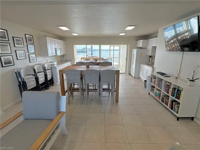 Dining area with light tile patterned flooring and baseboards