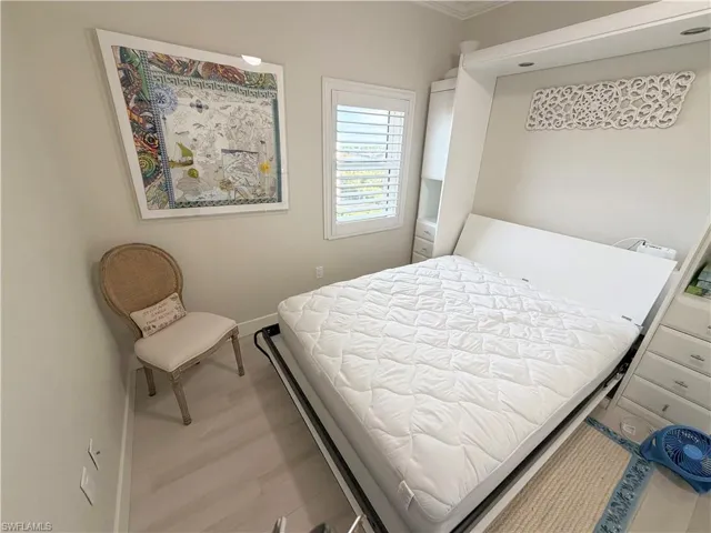 Bedroom featuring crown molding and light wood finished floors