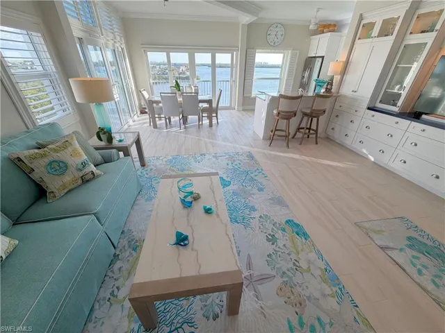 Living room with crown molding and light wood-style flooring