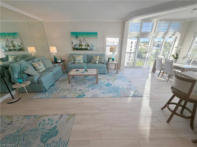 Living room with crown molding and light wood-style floors