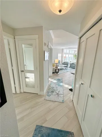 Hall with light wood finished floors and baseboards