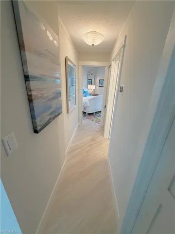 Corridor featuring baseboards and light wood-style floors