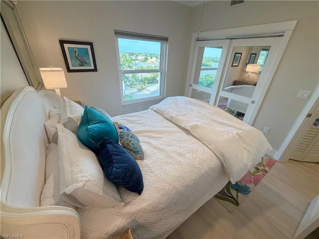 Bedroom with wood finished floors and a closet