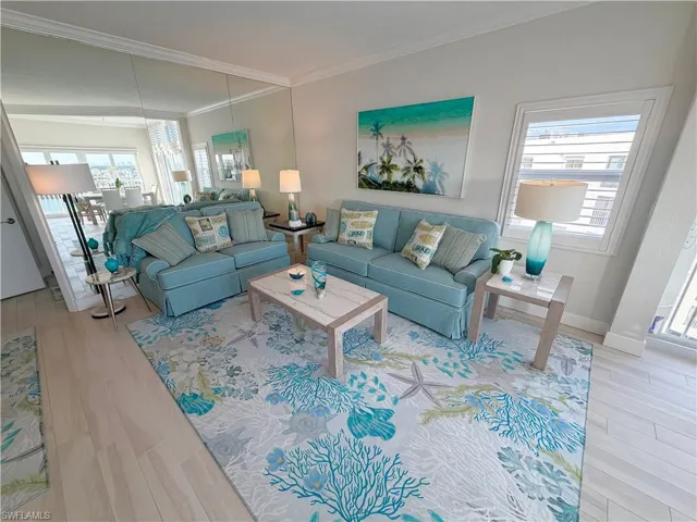 Living room with light wood-style flooring and ornamental molding
