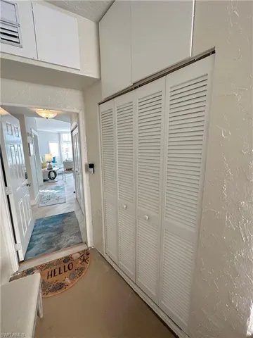 Hallway with a textured wall and concrete flooring