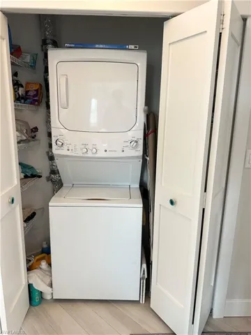 Laundry area featuring estacked washer and dryer and light wood-style floors