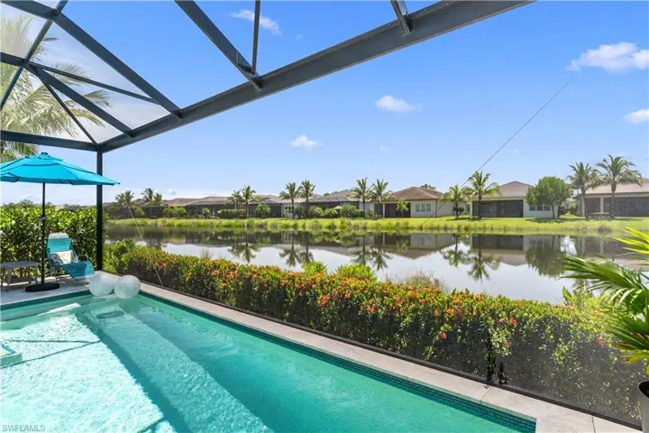 Outdoor pool with a water view, a residential view, and a lanai