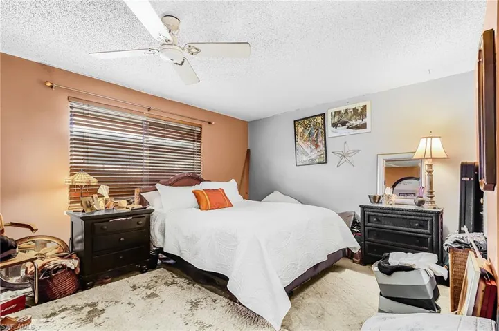 Bedroom with a textured ceiling and ceiling fan