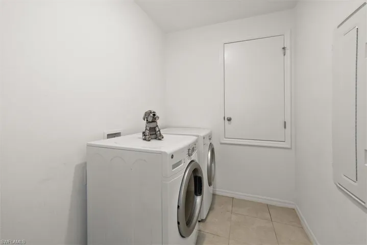 Laundry area featuring washer and clothes dryer and light tile patterned floors