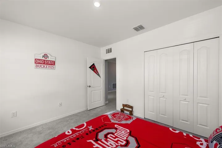 Carpeted bedroom with a closet and recessed lighting