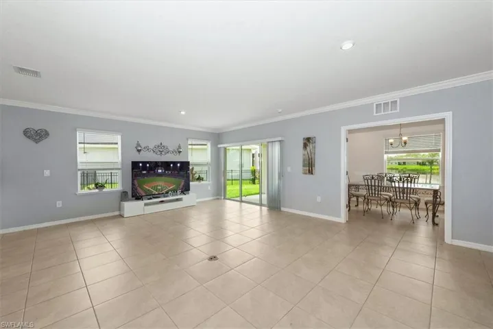 Unfurnished living room featuring ornamental molding, plenty of natural light, light tile patterned floors, and recessed lighting