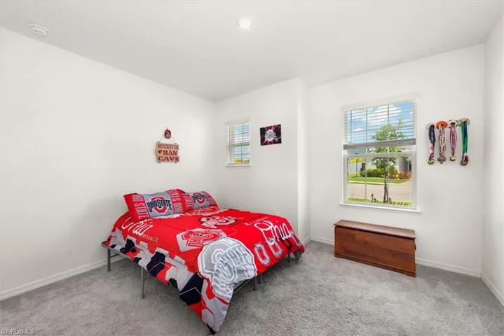 Carpeted bedroom featuring multiple windows