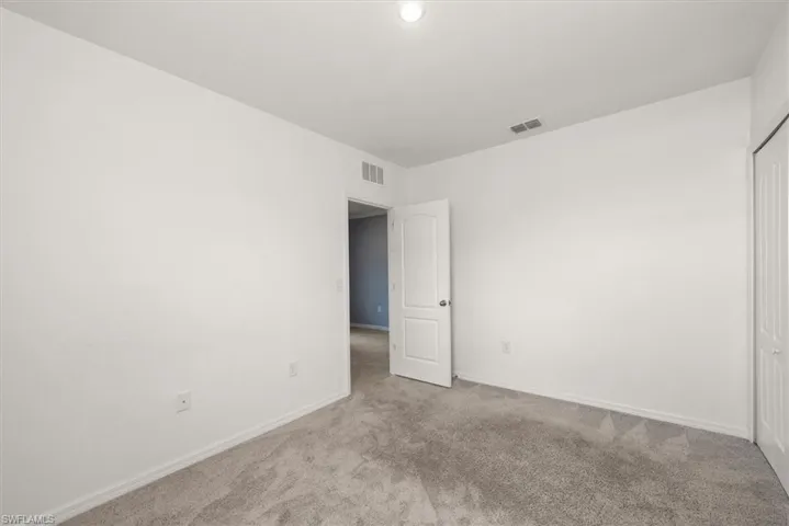 Carpeted empty room with baseboards and recessed lighting