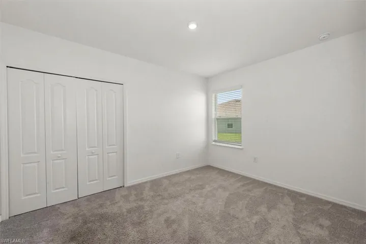 Unfurnished bedroom with carpet, a closet, and recessed lighting