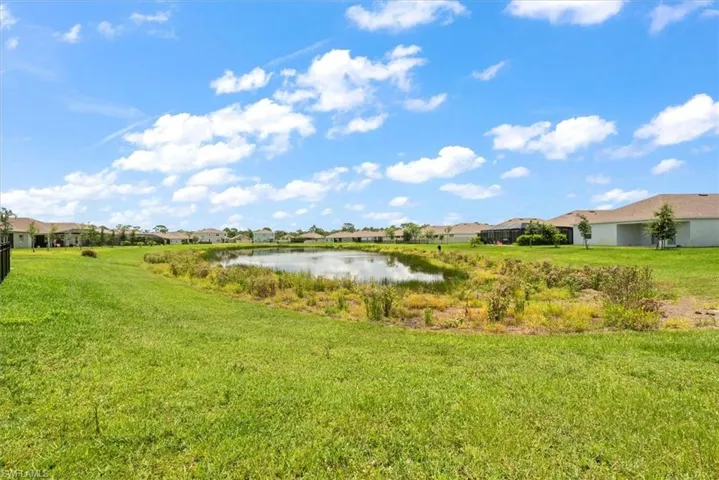 View of green lawn featuring a water view and a residential view